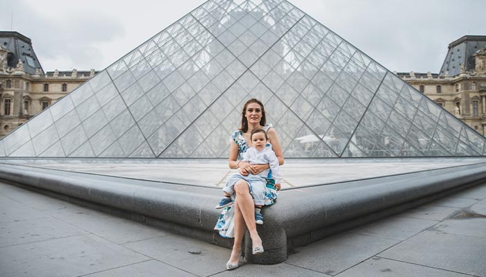 Familia posando en una sesión de fotos frente al Museo del Louvre