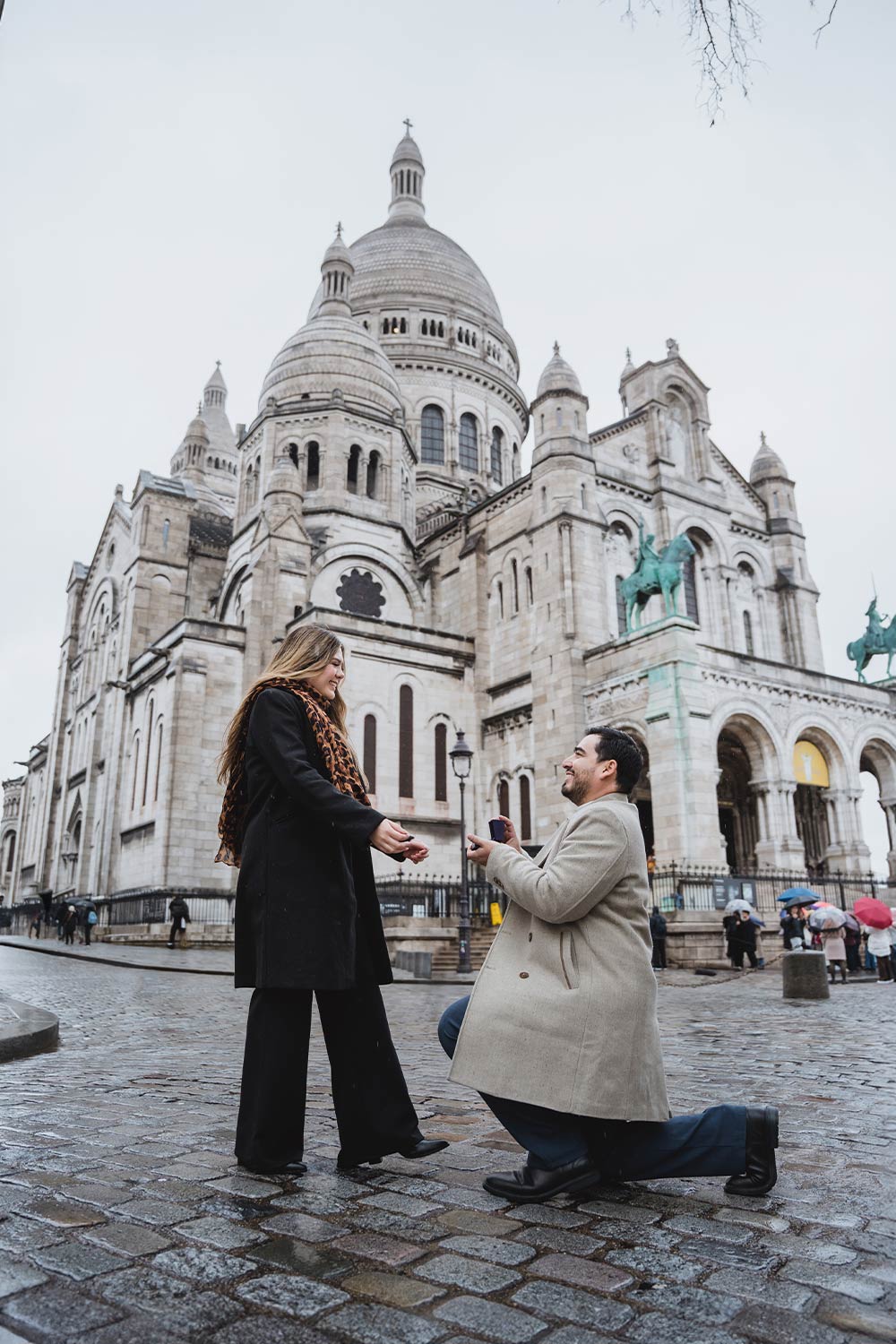 Hombre proponiendo matrimonio de rodillas frente a la Basílica del Sacré-Cœur en Montmartre, París / Man kneeling to propose marriage in front of the Sacré-Cœur Basilica in Montmartre, Paris